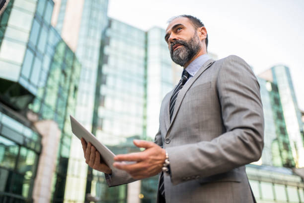 istock Mid adult businessman using digital tablet at financial district. 1336375954