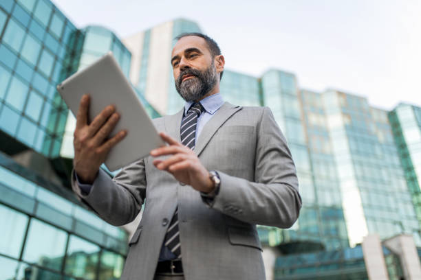istock Mid adult businessman using digital tablet at financial district. 1336375987