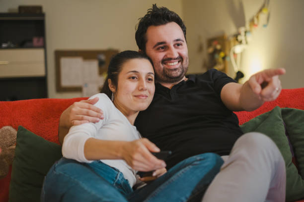 istock Young couple Watching TV at home 1336383256