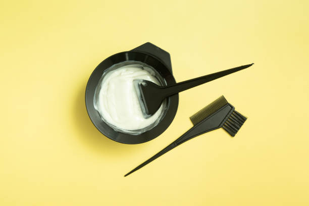 set for home or salon hair dyeing in the hands of a woman with gloves. Brushes and bowl for hair dye on yellow background set for home or salon hair dyeing in the hands of a woman with gloves. Brushes and bowl for hair dye on yellow background flaxen hair color stock pictures, royalty-free photos & images