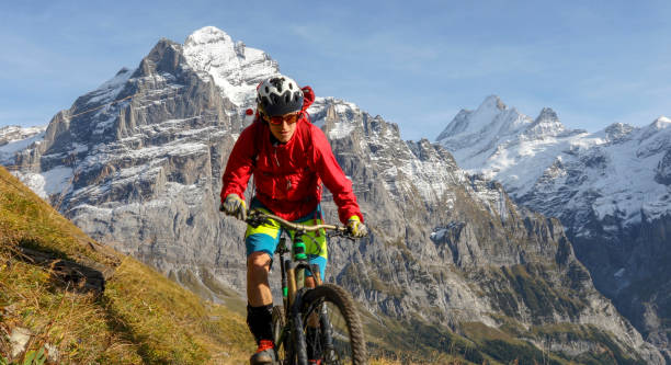 istock Mountain biker follows path along grassy mountain 1336387348