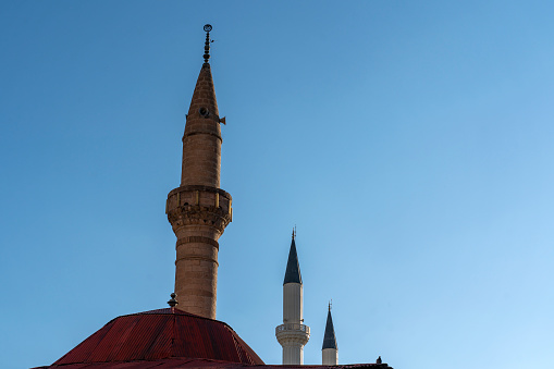Three old style minaret in front of blue sky in Turkey,