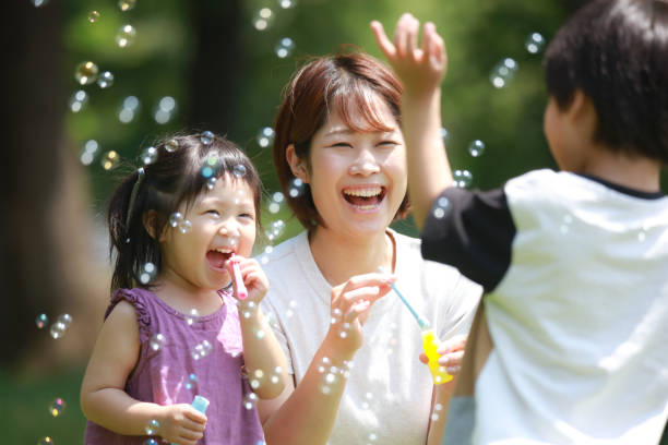 Parents and children playing with soap bubbles