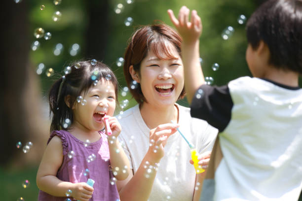 Parents and children playing with soap bubbles Parents and children playing with soap bubbles only japanese stock pictures, royalty-free photos & images