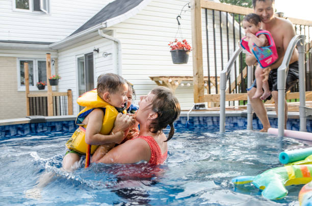 istock Mother playing in pool with kids 1336403122