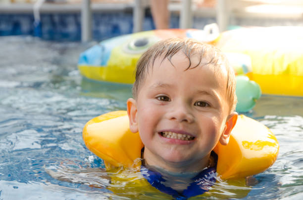 istock Mixed race boy swimming in pool 1336403151
