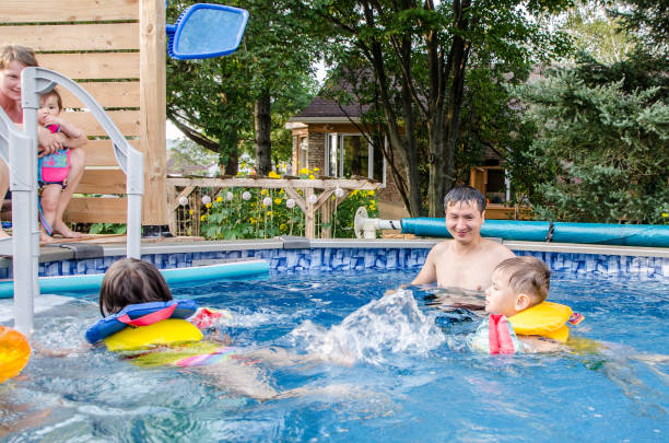 istock Mixed race children playing in pool under supervision 1336403191