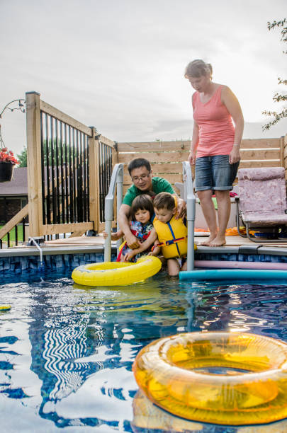 istock Parents and mixed race children entering in pool 1336403327