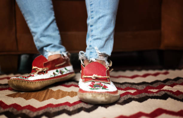 Feet in Beaded Native American Mocassins On Native Rug stock photo