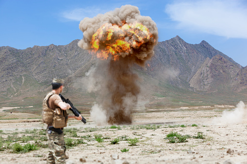 Army Soldier standing against explosion in battlefield