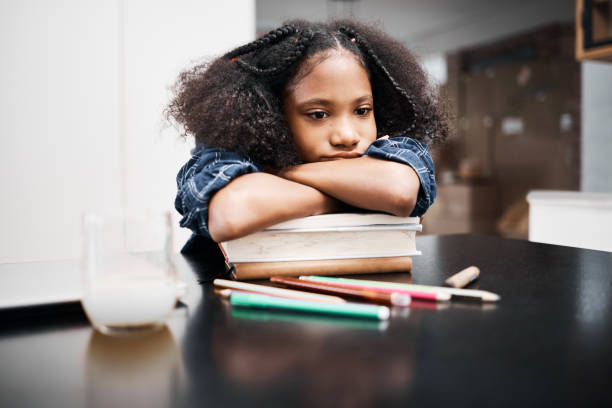 집에서 학교 과제를 하는 동안 불행해 보이는 어린 소녀의 샷 - learning boredom studying child 뉴스 사진 이미지