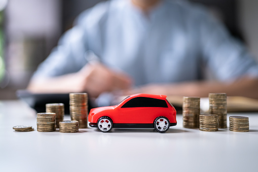 Toy Car In Front Of Businessman Calculating Loan