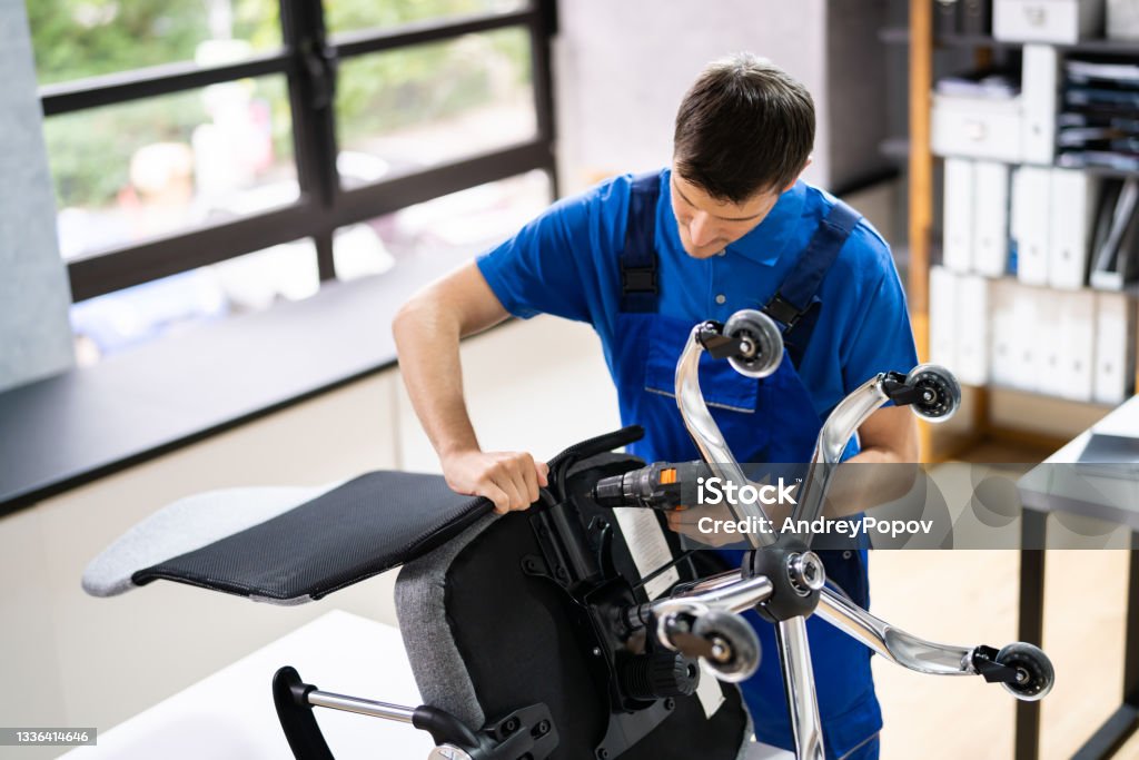 Office Chair Assembling And Repair Office Chair Assembling And Repair. Man Working With Tool Installing Stock Photo