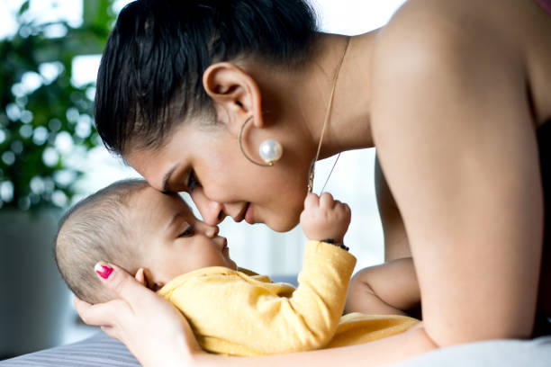 мать целует сына дома - baby kissing mother lifestyles стоковые фото и изображения