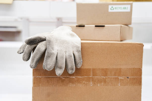 istock Portrait of work gloves on piled cardboard boxes 1336420222