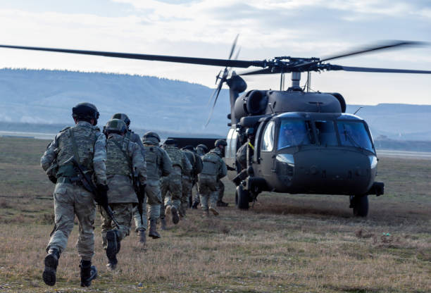 Turkish Army soldiers boarding military helicopter Ankara, Turkey - January 03, 2017: Turkish Army soldiers boarding a Sikorsky UH-60 Black Hawk military helicopter while some other soldiers providing covering fire. blackhawk stock pictures, royalty-free photos & images