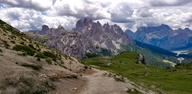 istock Mountain path with rocky peaks in the background surrounded by rain clouds 1336425205