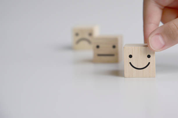 istock Close up customer hand choose smiley face and blurred sad face icon on wood cube, Service rating, satisfaction concept. 1336426117