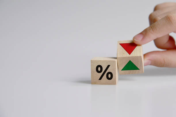 istock Hand is turning a dice and changes the direction of an arrow symbolizing that the interest rates are going down (or vice versa) 1336426121