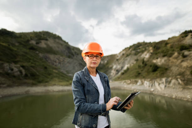 istock Female quarry engineer-architect uses a tablet, looking at the camera 1336429394