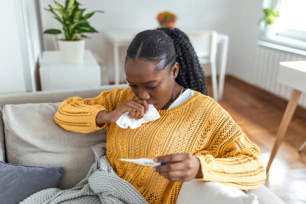 istock Sickness, seasonal virus problem concept. Woman being sick having flu lying on bed looking at temperature on thermometer. Sick woman lying in bed with high fever. Cold flu coronavirus, covid19 1336432059