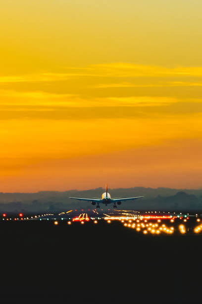 el avión despega de la pista del aeropuerto durante la puesta de sol al anochecer - runway airplane landing landing light fotografías e imágenes de stock