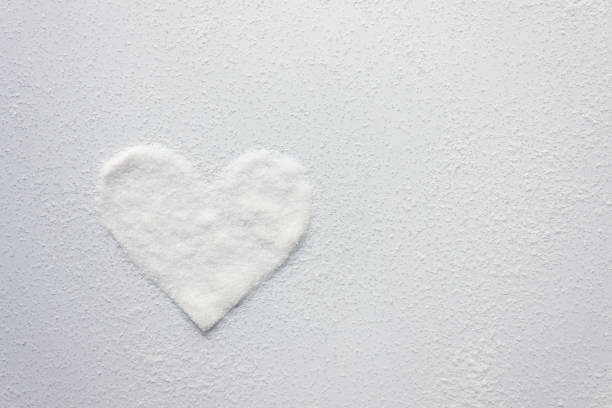 istock White sugar crystals in the shape of a heart. Copy space 1336440114