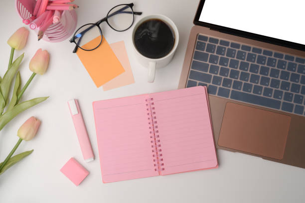 istock Woman workspace with laptop computer, notebook, coffee cup and pink tulips. 1336440788