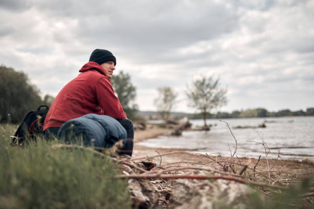 istock Hiker camping in nature on a river shore. 1336441418