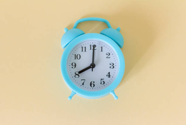 istock Blue vintage alarm clock on a light background. 1336442326