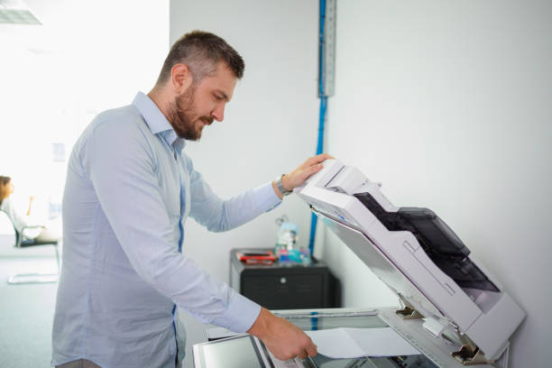 istock Businessman making copies of documents on xerox 1336442553