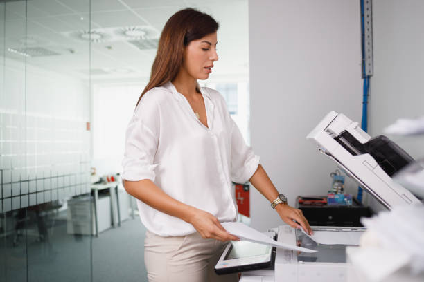istock Office clerk putting documents in xerox for making copies 1336442558