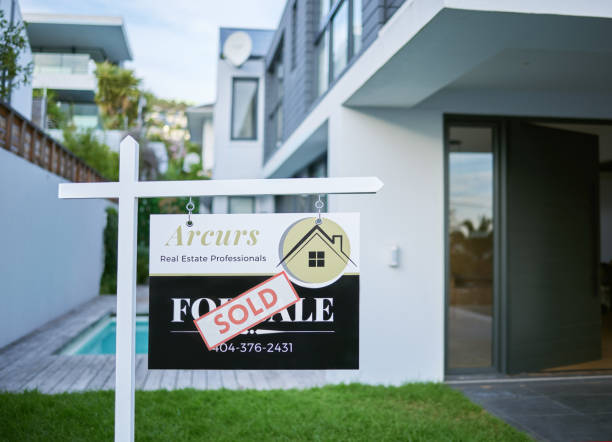 Shot of a sold sign in a yard of a newly bought house This house just became a home estate agency stock pictures, royalty-free photos & images