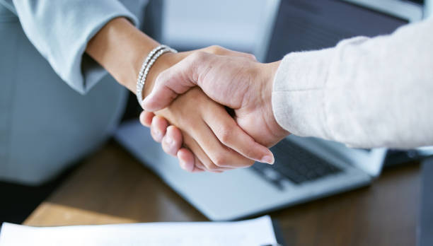 Shot of two unrecognizable businesspeople shaking hands Shaking on a successful business deal promotion employment stock pictures, royalty-free photos & images