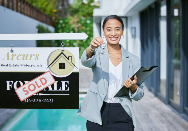 снимок молодой женщины-агента по недвижимости, держащей ключи от нового дома, который был продан - businesswoman advertise placard advertisement стоковые фото и изображения