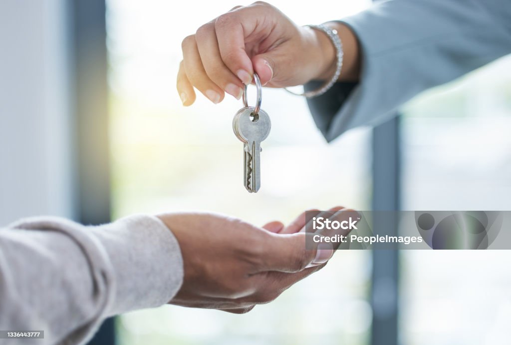 Shot of an unrecognizable person giving the keys to a house to a buyer Here are the keys to your new home Real Estate Agent Stock Photo