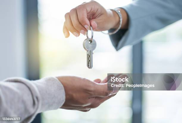 Shot Of An Unrecognizable Person Giving The Keys To A House To A Buyer Stock Photo - Download Image Now