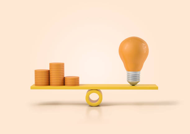 istock Light bulb with stack of coins on a scale. Electricity price concept 1336443912