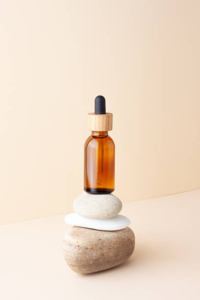 istock Cosmetic bottle with stones on pastel beige background. Close up, copy space 1336444985
