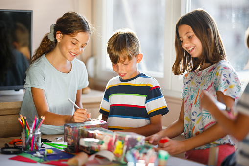 Group of children having fun making crafts at home
