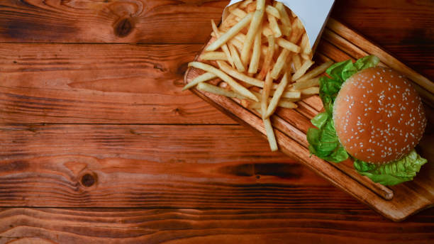 istock Fish burger and fried potatoes on wooden serving board. 1336448092