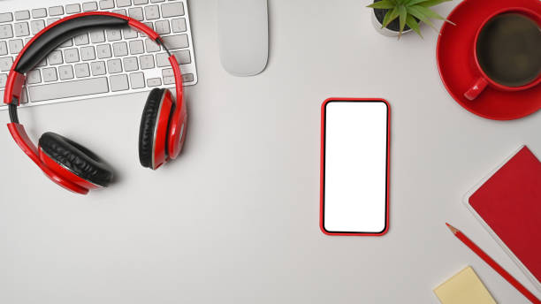 istock Mobile phone, coffee cup, headphone and notebook on white office desk. 1336448410