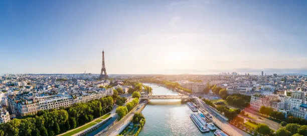 Photo of Paris aerial panorama with river Seine and Eiffel tower, France. Romantic summer holidays vacation destination. Panoramic view above historical Parisian buildings and landmarks with blue sky and sun