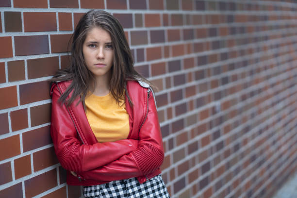 Unhappy teenager Portrait of a sad teenage girl in front of a brick wall sad 15 years old girl stock pictures, royalty-free photos & images