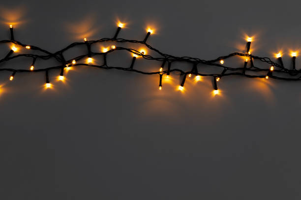 istock Glowing golden electric garland on a gray background 1336453082