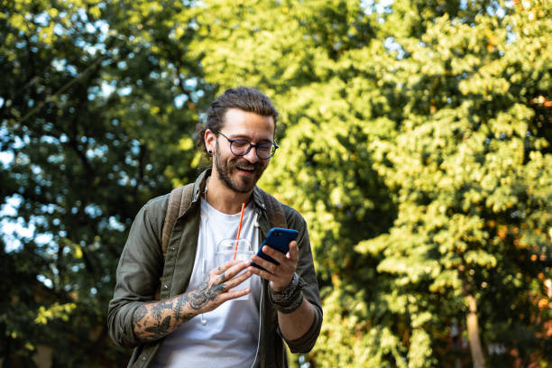 istock Young modern man using smart phone on the city street 1336453155