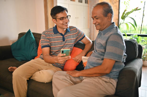 istock Mature mid aged son helping his senior father using latest technology smart phone 1336453338