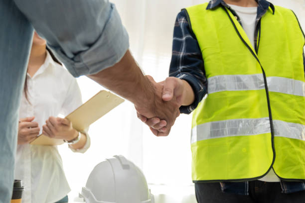 grupo de arquitectos e ingenieros trabajadores de la construcción socio apretón de manos en la oficina de la sala de reuniones en el edificio del sitio de construcción, industrial, asociación, contrato de construcción y concepto de contratista - hardhat construction men handshake fotografías e imágenes de stock