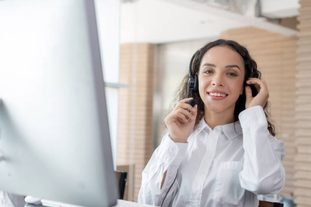 istock happy young caucasian female call center customer support executive with headset working looking at camera in office, online, customer support service, call center, phone operator, video call concept 1336457547
