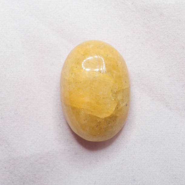 cabochon ovale beryll giallo naturale sullo sfondo bianco - berillo foto e immagini stock